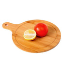 Round bamboo pizza chopping board with groove edge, shown with tomato and lemon, ideal for slicing and serving fresh ingredients.