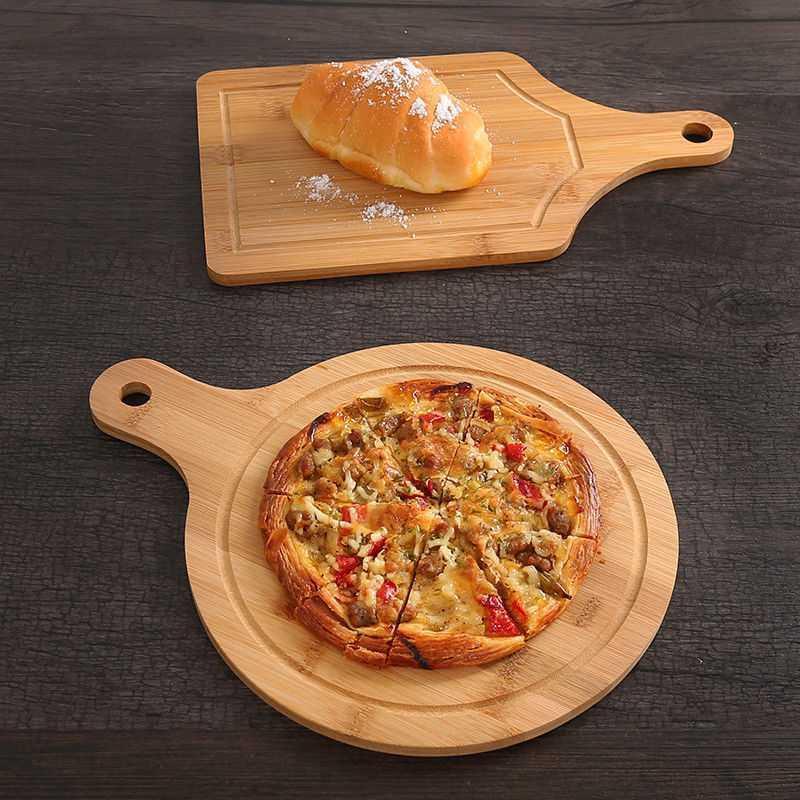 Round and rectangular bamboo pizza chopping boards with pizza and bread, ideal for serving and slicing. Durable bamboo fiber construction.