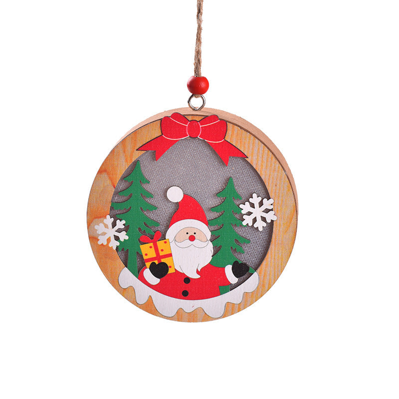 Round wooden New Christmas Tree Pendant with Santa holding a gift, flanked by snowflakes and pine trees, perfect for holiday decorating.
